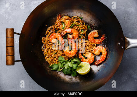 Faire sauter les nouilles ramen aux crevettes au wok casserole sur fond de béton gris close-up Banque D'Images