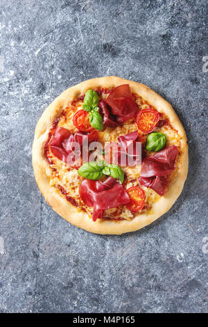 Pizza traditionnelle avec bresaola, fromage, tomates et basilic sur blue texture background. Vue de dessus avec l'espace Banque D'Images