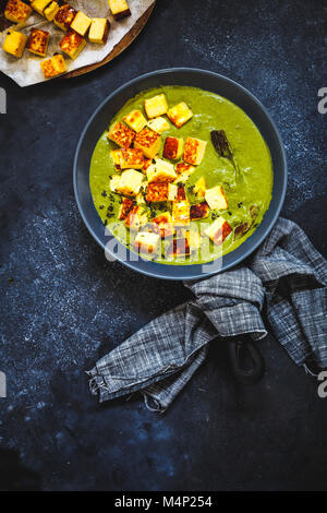 Cubes de paneer frit à mijoter dans une sauce aux épinards. Banque D'Images