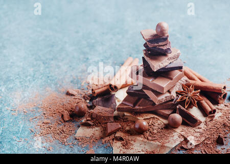 Pile de pièces en chocolat cassé sur une table de cuisine en marbre. Faire un dessert. Douceurs maison photographie avec copie espace. Banque D'Images