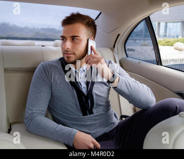 Homme barbu occasionnels de parler par smartphone dans une voiture. Banque D'Images