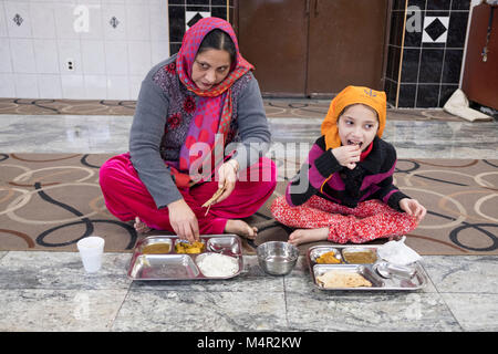 Une femme sikh indien et sa fille mangent ensemble au Baba Shah Makhan Lobana Centre Sikh sur 101 Avenue à Richmond Hill, Queens, New York City Banque D'Images