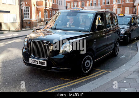 Cabine noirs de Londres a été vert comme un nouveau taxi électrique attend à l'extérieur Harrods à Knightsbridge de prendre des passagers sur les routes de la capitale. Banque D'Images