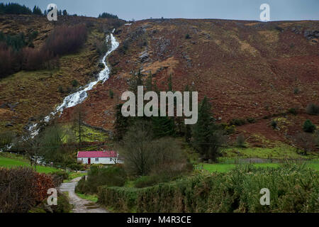 Gîte au toit rouge à la base d'une cascade de Glenmalure co wicklow Banque D'Images