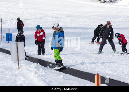 Enfants sur un tapis magique téléskis à l'bunny hill d'Anthony Lakes Mountain Resort, dans le nord-est de l'Oregon. Banque D'Images