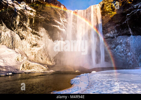 Cascade de Skogafoss en Islande derrière un arc-en-ciel spectaculaire Banque D'Images