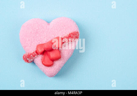 Saint Valentin en forme de coeur bonbons sur fond bleu avec l'espace vide pour votre texte. Banque D'Images