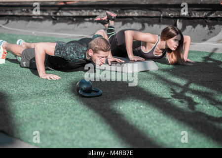 L'homme et de la femme sportive faisant pousser ups. Banque D'Images