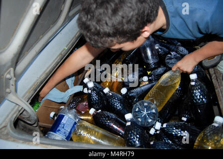 Un homme vendant du vin fait maison dans une des bouteilles en plastique de son coffre de voiture à Sudak, Ukraine Banque D'Images