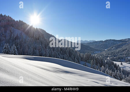 Profondément le paysage couvert de neige dans les Alpes avec Allgaeu forêts et le soleil à une belle journée d'hiver. La Bavière, Allemagne Banque D'Images