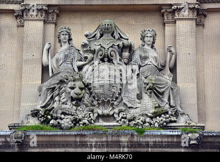 Une ancienne plaque de pierre ou de secours en pierre moulée armoiries ou emblèmes héraldiques au-dessus d'un lieu historique à l'ancienne porte sur une période bien. Banque D'Images