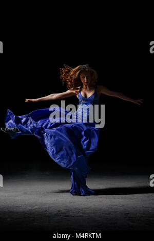 La danseuse dans l'obscurité, exécute des pirouettes. Banque D'Images