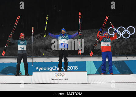 Pyeongchang. Feb 18, 2018. Martin Fourcade Champion (C) de la France, l'Allemagne est Simon Schempp (L) et troisième placé la Norvège est Emil Hegle Svendsen poser pour des photos au cours de la cérémonie le lieu men's 15km départ groupé à l'événement de biathlon aux Jeux Olympiques d'hiver de PyeongChang 2018 au Centre de préparation au biathlon d'Alpensia, Février 2018 ?18. Credit : Wang Haofei/Xinhua/Alamy Live News Banque D'Images