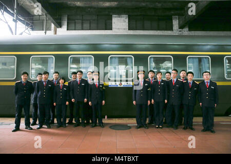 Shanghai. Feb 18, 2018. Chef d'orchestre Kan Xiaojun et ses collègues posent pour des photos sur une plate-forme de la gare de Guangzhou Est dans le sud de la province chinoise du Guangdong, le 18 février 2018. Le 42-year-old Kan Xiaojun est un chef d'orchestre de la Z99. Il a été de service pendant la Fête du Printemps les rush, également connu comme le Chunyun, depuis 12 ans et a raté une réunion de famille du festival pour sept fois. La plupart des membres de l'équipe de Kan viennent de Chine, région du delta du fleuve Yangtze. Parmi eux, le plus jeune accompagnateur est 20. Credit : Ding Ting/Xinhua/Alamy Live News Banque D'Images