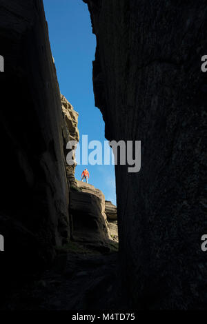 Walker et caverneuse rock formations à Hag's Head, les Falaises de Moher promenade côtière, comté de Clare, Irlande. Banque D'Images