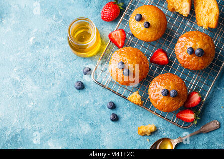 Muffins, gâteaux avec les baies fraîches et de miel sur grille de refroidissement. Vue d'en haut. Copier l'espace. Banque D'Images