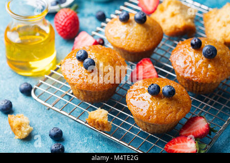 Muffins, gâteaux avec les baies fraîches et de miel sur grille de refroidissement. Banque D'Images