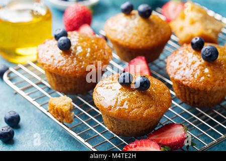 Muffins, gâteaux avec les baies fraîches et de miel sur grille de refroidissement. Banque D'Images