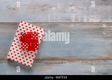 Boîtes cadeaux enveloppés dans du papier avec des rubans polkadots sur fond de bois, vintage retro style Banque D'Images