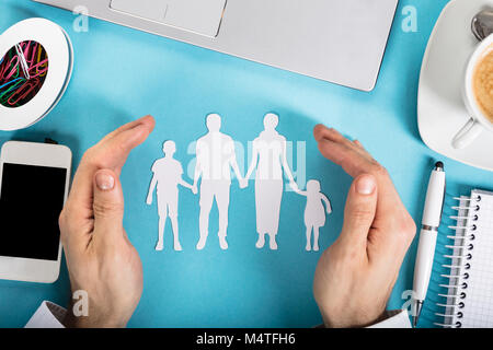 L'homme d'une part protéger le papier découpé avec la famille des fournitures de bureau sur Office 24 Banque D'Images