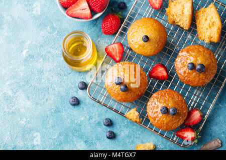 Muffins, gâteaux avec les baies fraîches et de miel sur grille de refroidissement. Vue d'en haut. Copier l'espace. Banque D'Images