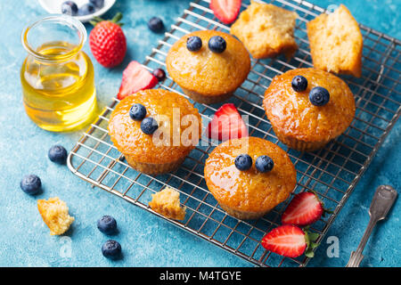 Muffins, gâteaux avec les baies fraîches et de miel sur grille de refroidissement. Banque D'Images