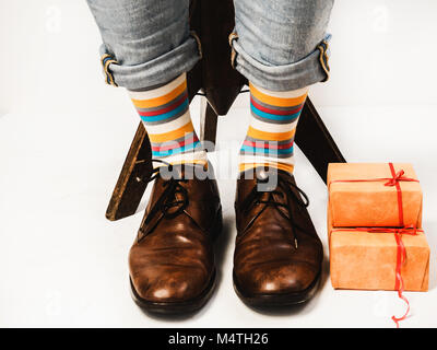 Bel homme drôle en chaussettes et chaussures élégantes avec un cadeau pour son être cher Banque D'Images