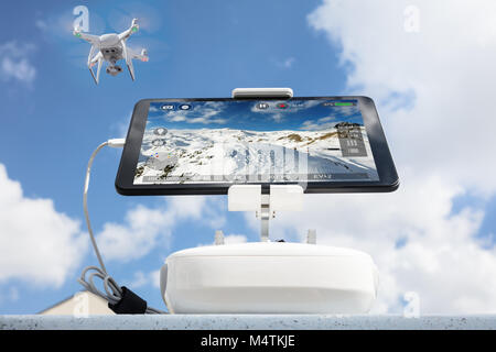 Low angle view of drone montagnes tournage vu sur tablet computer against cloudy sky Banque D'Images