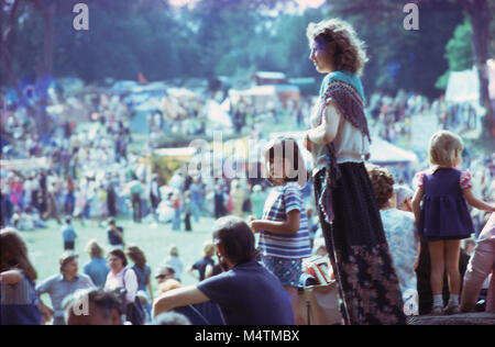 Vintage photo de belle hippie hippie femme mère, homme et enfants 70s 1970s soixante-dix été hippie festival de musique de mode hippie foule à Barsham Fair à Beccles, Suffolk Engalnd 1974 UK KATHY DEWITT Banque D'Images