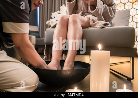 Jeune femme à boire le thé au cours de style balinais traditionnel massage des pieds Banque D'Images