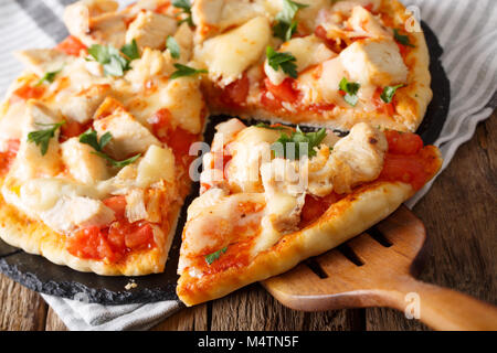 Petites tranches de pizza au poulet buffalo, tomates et fromage macro sur la table horizontale. Banque D'Images