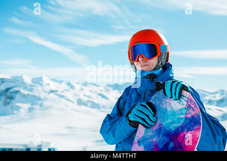 Photo de l'homme sportif en casque à la caméra avec en arrière-plan du harfang des neiges sur hill Banque D'Images