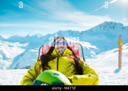 Photo de sport femme avec casque posé sur un fauteuil en hiver resort Banque D'Images