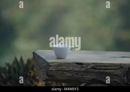 Café chaud sur l'ancien log with nature background Banque D'Images