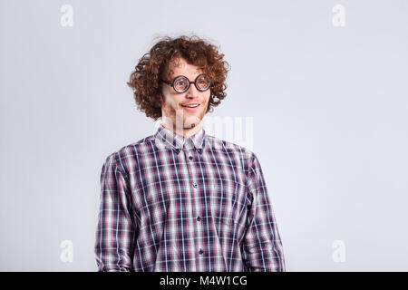 L'Homme à lunettes nerd bouclés avec un stupide genre de drôle d'émotion. Banque D'Images