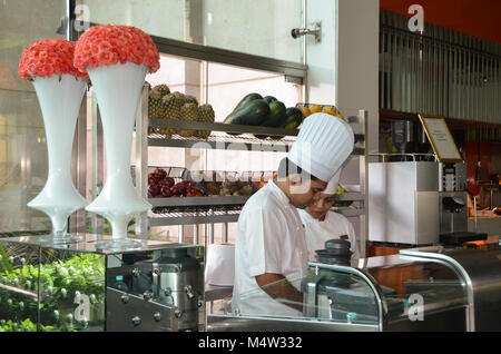 Chefs, portant haut blanc toques, préparer la nourriture au petit-déjeuner buffet au Leela Palace, un hôtel de luxe à New Delhi, Inde. Banque D'Images