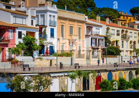 Maisons coloniales colorées avec portes en bois peint de couleurs vives sur la rue ci-dessous niveau face à la plage et l'océan à Gérone, Espagne. Banque D'Images