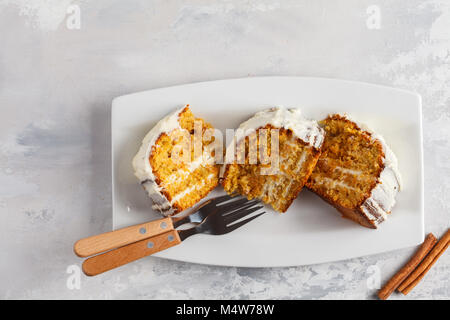 Morceaux de gâteau de carotte fait maison avec crème blanc sur blanc plat. Dessert de fête concept. Banque D'Images