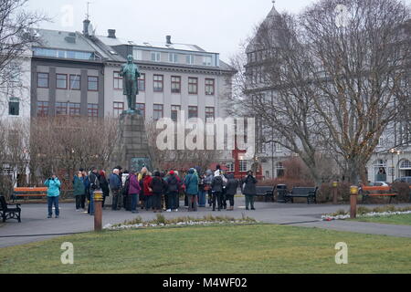 Une visite à pied de touristes par la statue de Jón Sigurðsson dans Parc Austurvöllur en face de la Maison du Parlement à Reykjavik, Islande Banque D'Images