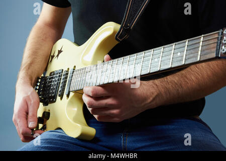 Mains d'un jeune homme tenant une guitare électrique Banque D'Images