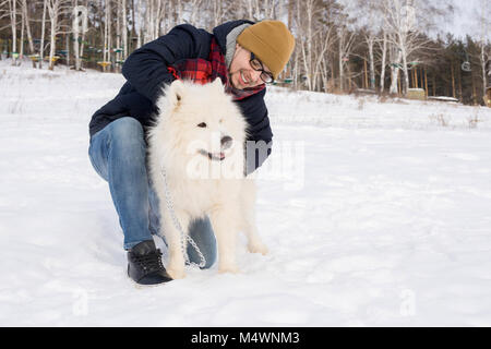 Portrait de l'homme moderne pour enfants adultes blanc Samoyède chien sur belle journée d'hiver, copy space Banque D'Images