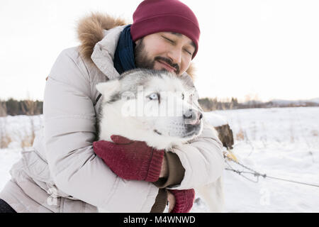 Portrait de l'homme asiatique barbu hugging superbe chien husky bénéficiant d'étioler jour sur nice promenade dans les bois, copy space Banque D'Images