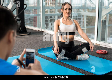 Portrait de jeune femme fit poser pour la photo au cours de la pratique du yoga en club de remise en forme moderne, copy space Banque D'Images