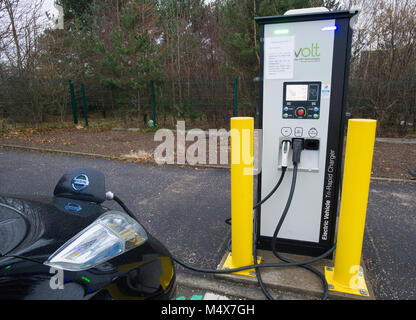 Une Nissan Leaf voiture électrique à l'aide d'un chargeur rapide à une station de recharge de véhicules électriques, Riccarton, Edinburgh. Banque D'Images