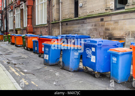 Le centre-ville de Manchester rue arrière recouvert de plastique bleu bacs alimentaires frais et refuser, UK Banque D'Images