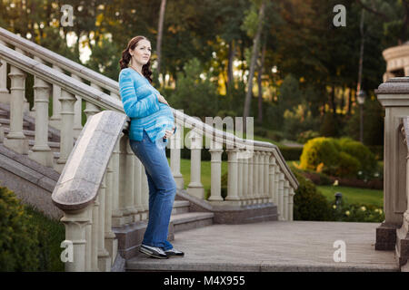 Portrait d'une belle femme enceinte, elle mit ses mains sur son ventre. Banque D'Images