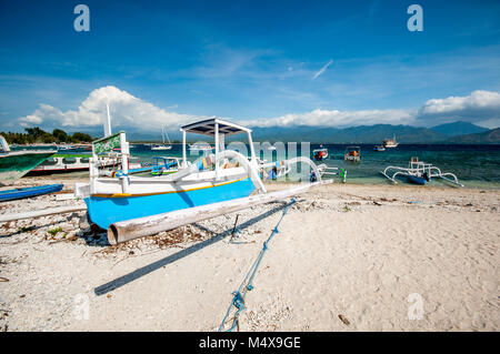 Bateaux sur la plage et sur la mer et vue de l'île Lombok en arrière-plan. L'île de Gili Air, l'Indonésie. Banque D'Images