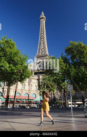 Jeune femme marche sur le trottoir, à l'arrière-plan de l'Hôtel de Paris, Las Vegas, Nevada. Banque D'Images