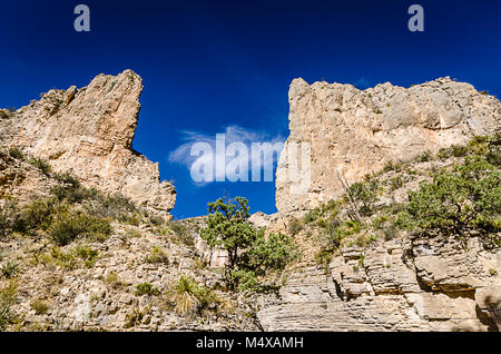 L'ouverture de serrure à ciel bleu vif dans les falaises du canyon sur Devil's Hall trail à Guadalupe Mountains National Park au Texas. Banque D'Images