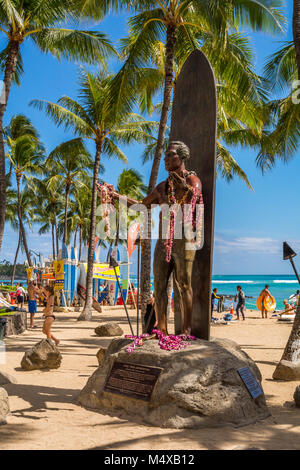 La statue de Duke Kahanamoku, célèbre surfeur hawaïen et Olympien sur Waikiki Beach avec les baigneurs, les surfeurs, les touristes dans la région de Honolulu, Oahu, Hawaii, USA. Banque D'Images